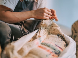 Coffee bean worker fixing a sack