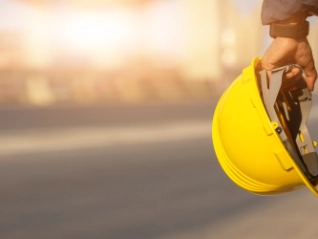 Construction worker holding safety helmet
