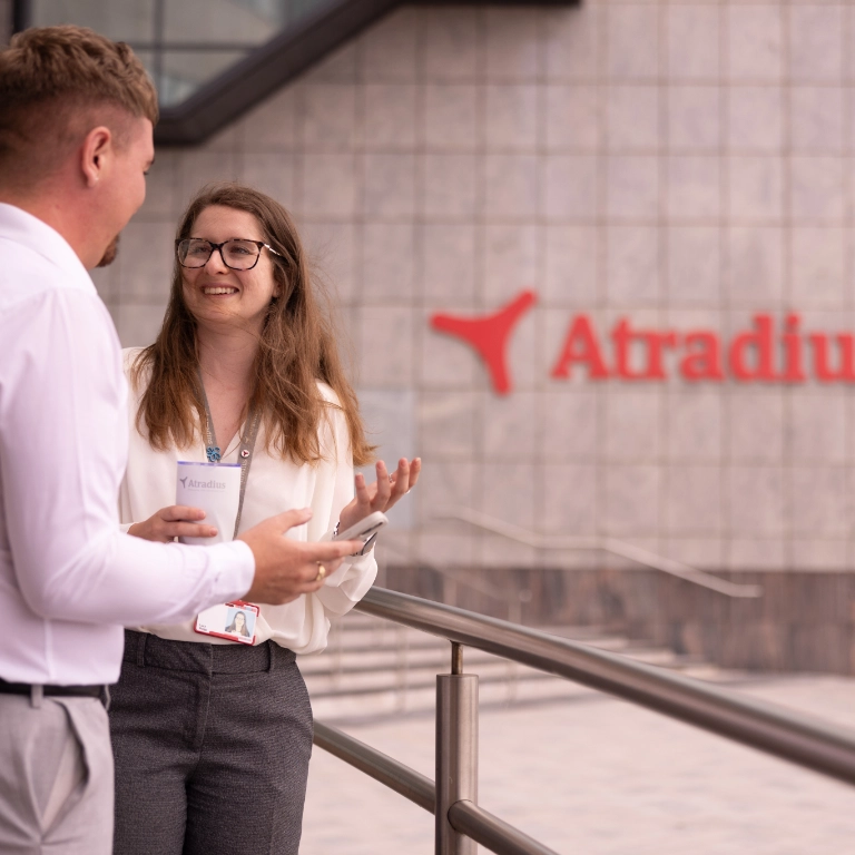 Woman and man have coffee break outside at the entrance of the Cardiff office