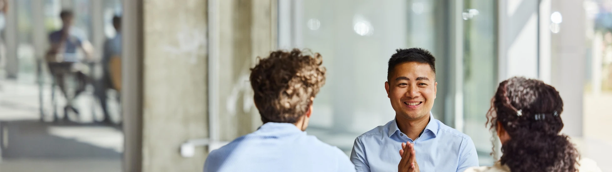 two men and woman talking at a table zoomed in