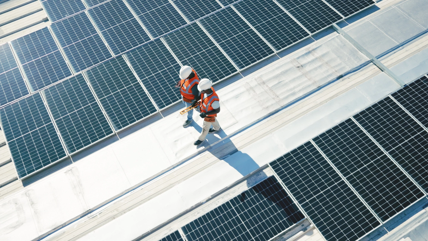 Two solar panel workers walking alongside panels