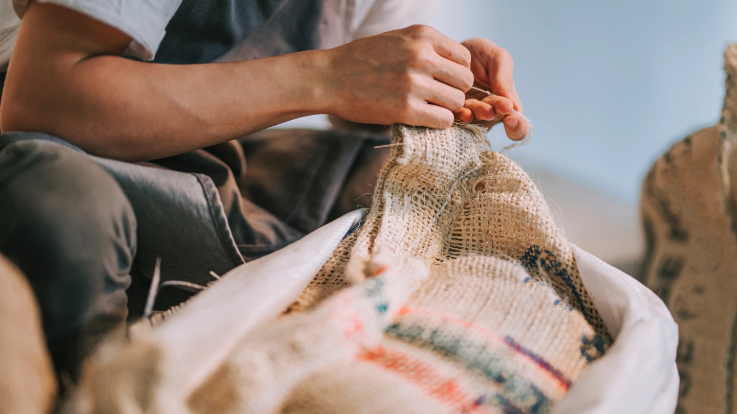 Coffee bean worker fixing a sack Coffee bean worker fixing a sack