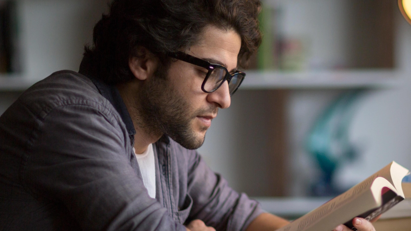 Knowledge and researching zoomed in image of man reading and using laptop Knowledge and researching zoomed in image of man reading and using laptop