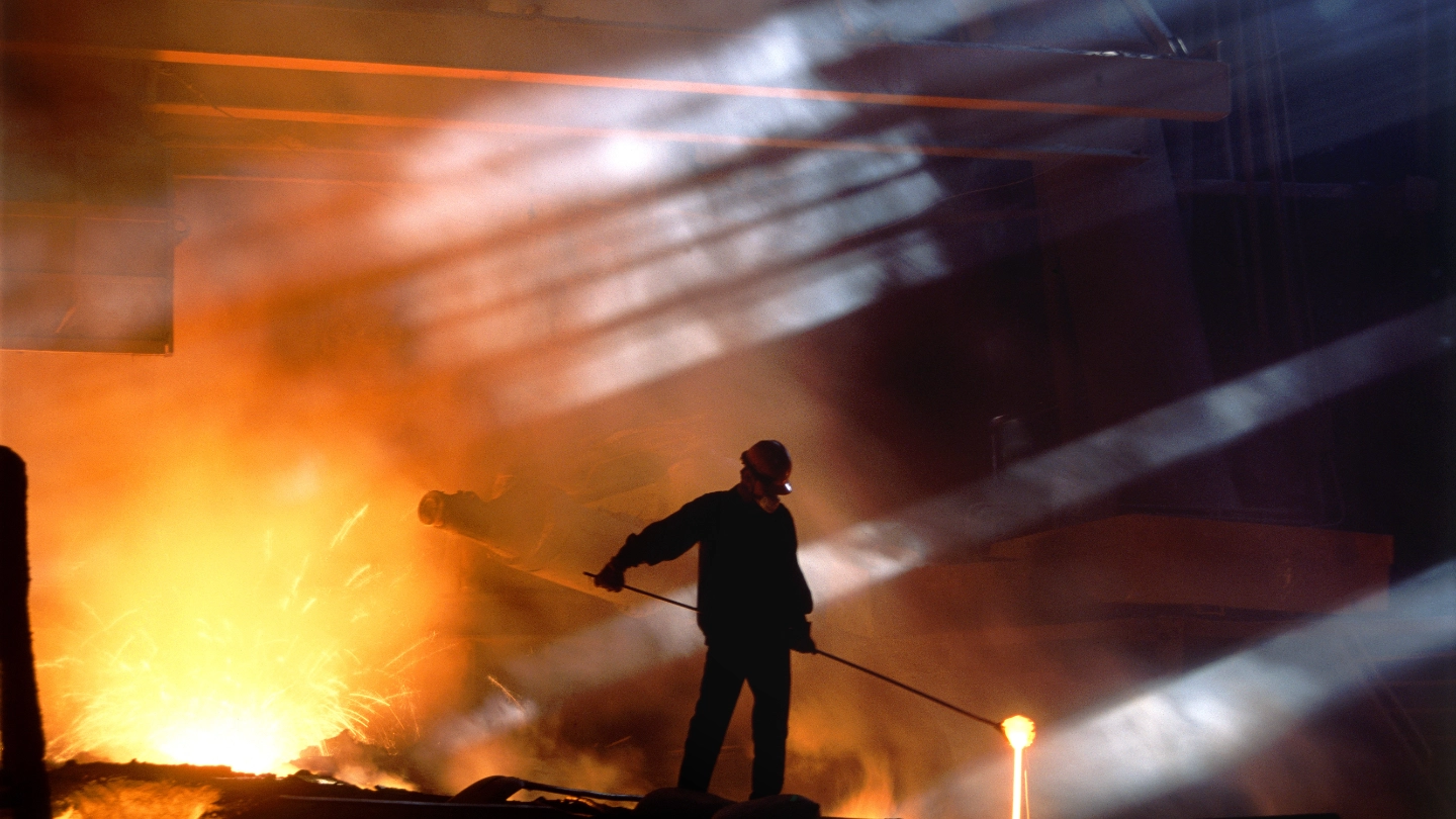 Smelting worker moving ore in landscape shot Smelting worker moving ore in landscape shot