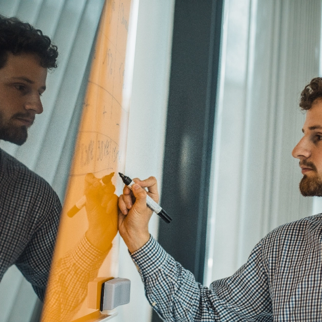 Atradius Colleague working on a board in the Paris Office
